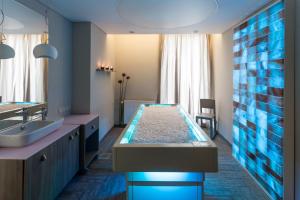 a bathroom with a tub with a sink and a mirror at Estonia Resort Hotel & Spa in Pärnu