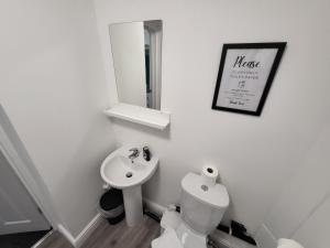 a bathroom with a sink and a toilet and a mirror at Nottingham Forest Rd, Short Stays in Nottingham