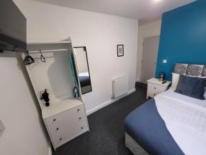 1 dormitorio con cama y espejo grande en Nottingham Forest Rd, Short Stays en Nottingham
