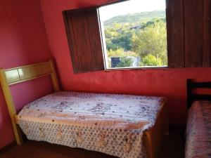 una piccola camera da letto con un letto e una finestra di Sítio Candeias - Diamantina MG a Diamantina Altre 26 foto