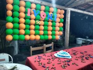 een kamer met een tafel met groene en oranje ballonnen bij Sítio Candeias - Diamantina MG in Diamantina