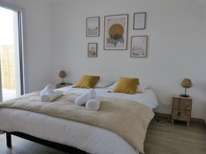ein Schlafzimmer mit einem großen Bett mit Handtüchern darauf in der Unterkunft Villa Ty Plad, Penmarc'h in Penmarcʼh