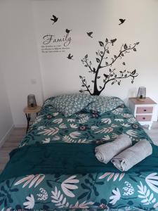 um quarto com uma cama com uma árvore na parede em Duplex centre ville em Ernée