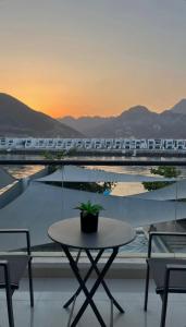 a table with a potted plant on a balcony with a train at Sunset villa in Fujairah