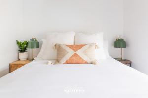1 cama blanca con almohadas blancas y 2 lámparas en The Birch Suite at Portage House in Picton, en Picton