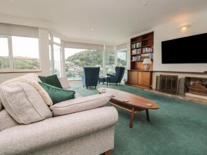 a living room with a couch and a tv at Pine Lodge - Private Parking in Kingswear
