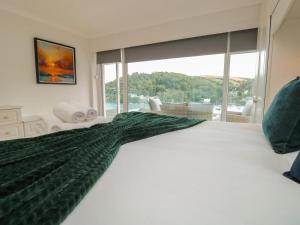 a bedroom with a large bed with a large window at Pine Lodge - Private Parking in Kingswear