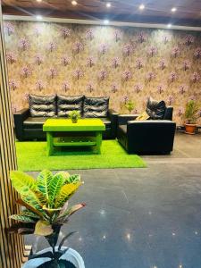 ein Wohnzimmer mit einem Sofa und einem Tisch in der Unterkunft PuHoR Hotel Plaza Inn in Guwahati