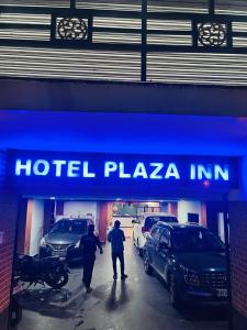 PuHoR Hotel Plaza Inn في غاواهاتي: رجلين واقفين امام فندق بلازا ان