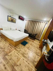 PuHoR Hotel Plaza Inn في غاواهاتي: غرفة نوم فيها سرير وتلفزيون