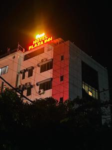 ein Gebäude mit einem Neonschild darüber in der Unterkunft PuHoR Hotel Plaza Inn in Guwahati