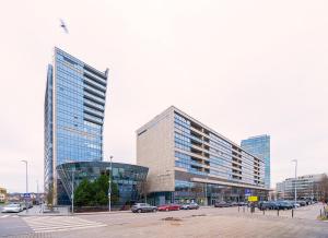 dos edificios altos en una ciudad con coches aparcados en Gynėjų Apartments - Lollo Luxury, en Vilna