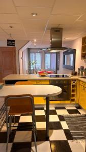 a kitchen with yellow cabinets and a table and chairs at La maison des copains in Damery