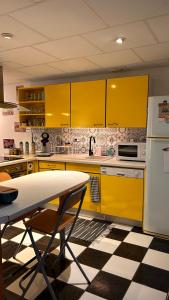a yellow kitchen with a table and yellow cabinets at La maison des copains in Damery