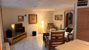a living room with a flat screen tv and a couch at La maison des copains in Damery