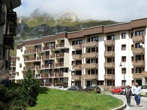 zwei Menschen, die vor einem Gebäude die Straße hinuntergehen in der Unterkunft Appartement Tignes, 3 pièces, 6 personnes - FR-1-502-484 in Tignes