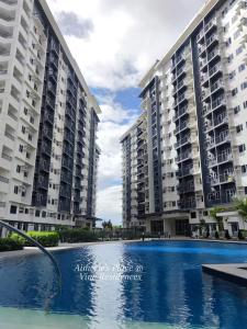 two large apartment buildings with a swimming pool at Vine Residences -Cozy 2BR with Balcony in Manila