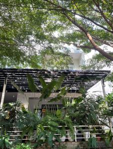 a house with a black roof and some trees at The Highland House in Buon Ma Thuot