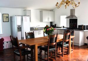 cocina con mesa de madera con sillas y nevera en Family Retreat or Romantic Break, 