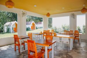 a dining room with tables and chairs and windows at Sea Bear Resort ซีแบร์รีสอร์ต in Ko Phayam
