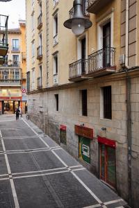 an empty street in a city with buildings at TuApartamento Loft - Fuente de Navarrería in Pamplona