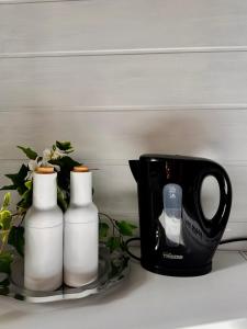 a black mug next to two white bottles on a plate at Wohnung Alte Mainbrücke - GRATIS KAFFEE - NETFLIX - BALKON in Würzburg