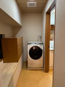 uma máquina de lavar e secar no canto de uma sala em WuTong梧桐 通天閣徒歩1分 NEW OPEN 景区内民宿 em Osaka