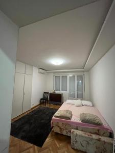 a bedroom with a bed and a desk in it at Stan na dan Niš in Niš