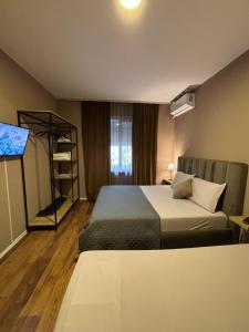Cette chambre comprend un lit et une télévision. dans l'établissement BejartApartment2, à Tirana
