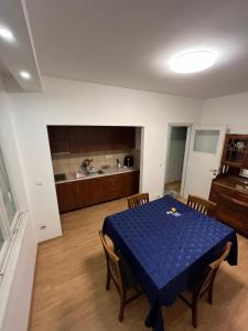 a dining room with a blue table and a kitchen at Stan na dan Niš in Niš