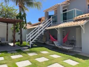 a house with a patio and a lawn at Charlotte House in Canoa Quebrada