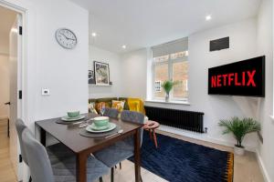 a kitchen and living room with a table and chairs at Luxury 1 Bed Flat - Shoreditch, Spitalfields & The City of London in London