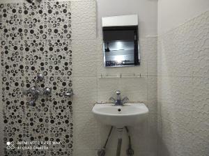 a white bathroom with a sink and a mirror at Lake View Lodge Sarangkot in Pokhara