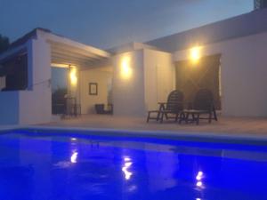 een zwembad voor een huis 's nachts bij Estupenda casa rural en Hinojos in Hinojos