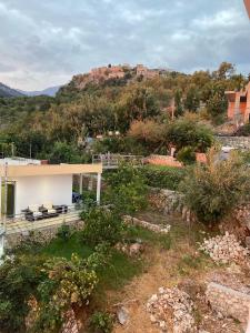 a house on a hill with a castle in the background at Persephone in Himare