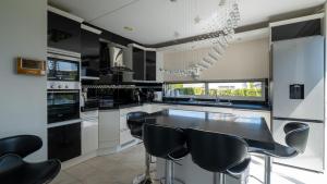 una cocina con electrodomésticos en blanco y negro y taburetes negros en Big 5-bedroom house in Capelle aan den IJssel en Capelle aan den IJssel
