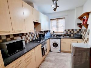 a kitchen with a sink and a stove top oven at Spacious two bedroom apartment with one parking space in Thame