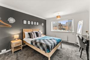 a bedroom with a bed and a desk and a window at Stunning Abode in Ashford - Parking - Sleeps 7 in Skegby