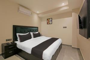 a bedroom with a large bed and a flat screen tv at Collection O Tunight in Ghaziabad