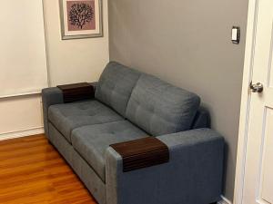un sofá gris en una sala de estar junto a una puerta en APARTAMENTO PROVIDENCIA, en Santiago