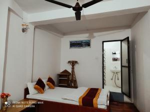 a bedroom with a bed and a ceiling fan at Lake View Lodge Sarangkot in Pokhara