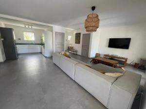 - un salon avec un canapé blanc et une télévision dans l'établissement Orient Bay Villa, à La Baie-Orientale