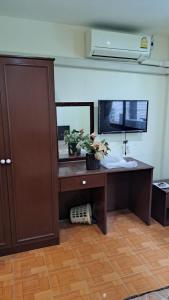 a desk with a mirror and a sink in a room at OM INN in Bangkok