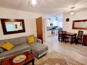 uma sala de estar com um sofá e uma mesa em Spacious two bedroom apartment with one parking space em Thame