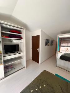 a room with a bed and a tv in a room at Belle chambre spacieuse, tropézienne, vue remparts, clim, parking in Aigues-Mortes