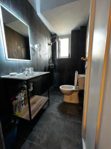 La salle de bains est pourvue d'un lavabo et de toilettes. dans l'établissement BejartApartment2, à Tirana