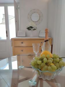 een kom druiven en een fles wijn op een tafel bij L'Archetto romantic suite in the center of Anacapri in Anacapri