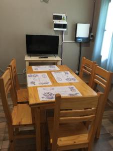 mesa de madera con sillas y escritorio con TV en Posada Enki en Puerto Iguazú