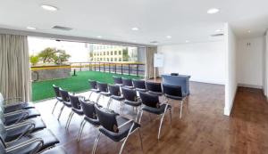 a conference room with chairs and a large window at George V Alto de Pinheiros Apto 208 Luxo - Adm Privada - Café da manhã in Sao Paulo +26 photos