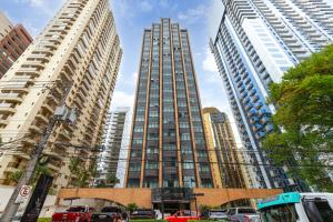 a tall building with cars parked in a city at SOL - Flats Av Cauaxi By Anora Spaces in Barueri